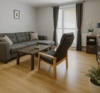 Living room in a family house with a comfortable couch and wooden decor flooring.