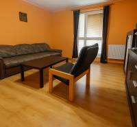 Living room in a family house with orange walls and a wooden decor floor.