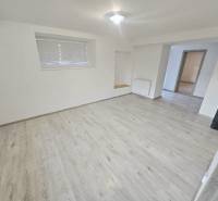 Living room of a three-room apartment with a wooden decor floor and an electric stove.