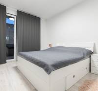 Bedroom with a bed, nightstands, and curtains in a two-room apartment.