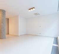 A spacious room in a 4-room apartment with white walls and a prominent concrete column.