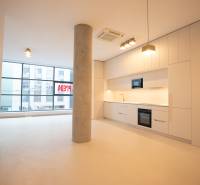 A kitchen in a 4-room apartment with white cabinets, a column, and large windows.