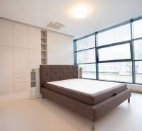 A bright bedroom with large windows and a built-in wardrobe in a four-room apartment.