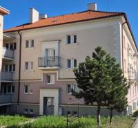 An older brick building with balconies and a red roof, suitable for a 2-room apartment in Nitra.
