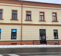 A building with commercial spaces on St. Nicholas Square in Stará Ľubovňa covered with snow.