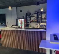 Modern commercial spaces with a bar counter, a vending machine, and comfortable seating.