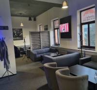 Bright commercial space with comfortable seating and a television on the wall.