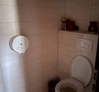 A restroom with tiles and a paper dispenser in commercial premises.