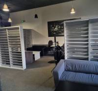 Commercial space with a sofa, white shelves, and carpeted flooring.