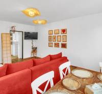 A family house with a red sofa, white furniture, and a floor with a wood decor.