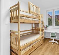 Bunk bed, desk, and chair in a family house with a wooden decor floor.