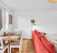 Dining area in a family house with a red sofa, wood-patterned flooring, and decorations.