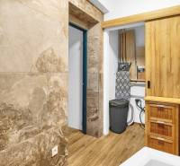 A bathroom in a family house with a wooden decor floor and sliding doors.