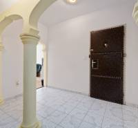A hallway with ornamental tiles and columns in a 3-room apartment.