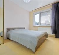 Bedroom in a 3-room apartment with a bed, mirrored wardrobe, and large window.