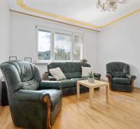 Living room in a 3-room apartment with a leather sofa set and a wooden table.