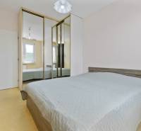 A bedroom with a mirrored wardrobe in a 3-room apartment has a bed and a window.