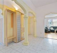 Interior of a 3-room apartment with arched doorways, tiled floor, and a view of the living room.
