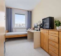 A children's room in a three-room apartment with wooden furniture, a small table, and a computer.