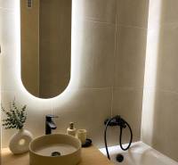 Elegant bathroom in a 4-room apartment with an illuminated mirror and stylish sink.