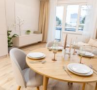 Dining table with a set of dishes, glasses, and a wooden decor floor in a 4-room apartment.
