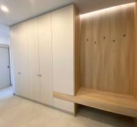 Built-in wardrobe and bench with wood decor in a 4-room apartment.