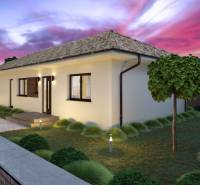 A family house in Gabčíkovo with a landscaped garden at sunset, with a paved driveway.