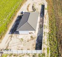 Aerial view of a family house in Gabčíkovo surrounded by fields and a road.