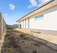 A family house in Gabčíkovo with a side view of the white facade and fencing.