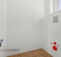 A family house bathroom with a wooden decor floor and white tiles.