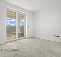 Empty room with large windows and a view of the exterior of a family house.