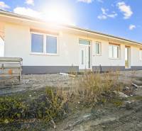 A family house in Gabčíkovo with a white facade and a trailer in front of the entrance.