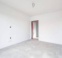Empty room with white walls and a concrete floor in a family house.