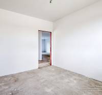 Empty room with white walls and a concrete floor in a family house.