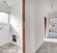 The interior of a family house with an unfinished floor and white walls.