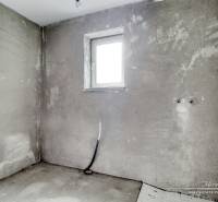 Concrete wall and small window in the interior of a family house.