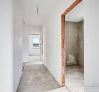 Interior of a family house with unfinished walls and a view of the concrete floor.