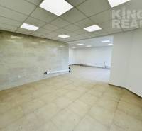 Spacious commercial spaces with tiles, white walls, and ceiling lights.