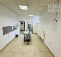Commercial premises with tiles, white walls, and a table in the middle of the room.