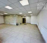 Commercial spaces with white walls, tiles, and modern ceiling panels.