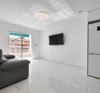 Living room of a 3-room apartment with elegant tiles and a balcony, television, and a sofa set.