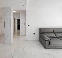 Interior of a 3-room apartment with a gray sofa and marble floor decor.