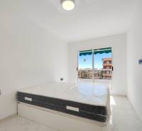 Bright bedroom with a bed and balcony doors in a 3-room apartment.