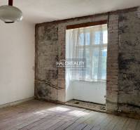 A room with exposed brick and a wood-patterned floor in a family house.