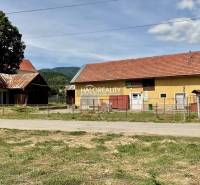 A building in Jasení with a red roof and a fenced plot.