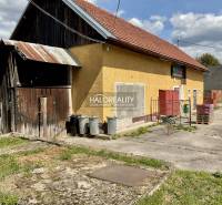 A family house in Jasenie with a wooden shed and an asphalt yard.