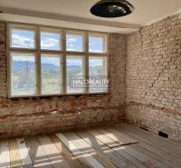 A room with brick walls and a wood-patterned floor in a family house.
