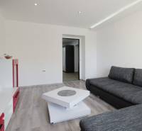 Living room with a corner sofa and television in a 2-room apartment, floor with wood decor.