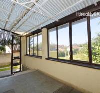 The veranda of a family house in Hegyeshalom with glazing and a view of the garden.
