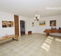 A bright living room in a family house with a grand piano and artistic paintings on the walls.